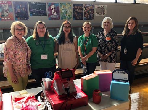 group of 6 women stand at check out table